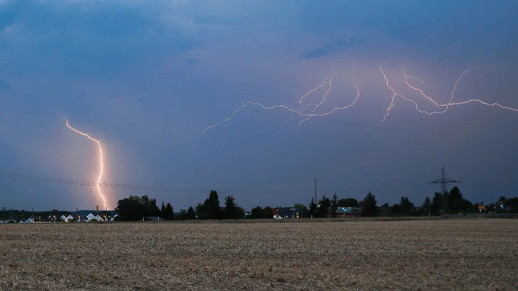 Ein-Blitz-erhellt-bei-einem-abendlichen-Sommergewitter-den-Himmel-ueber-Dornstadt