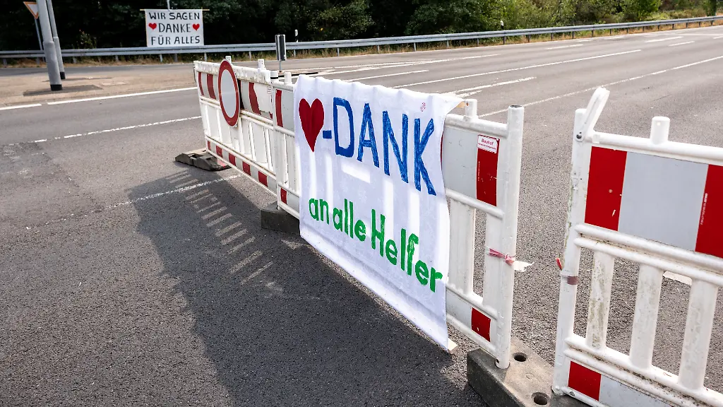 Die-Bewohner-der-Ortschaft-Gey-danken-den-Rettungskraeften-fuer-den-Einsatz-im-Waldbrandgebiet-im-Huertgenwald-mit-einem-Transparent-mit-der-Aufschrift-Wir-sagen-Danke-fuer-alles-Seit-15-08-2026-koennen-die-Menschen-nach-der-Evakuierung-wieder-offiziell-zurueckkehren