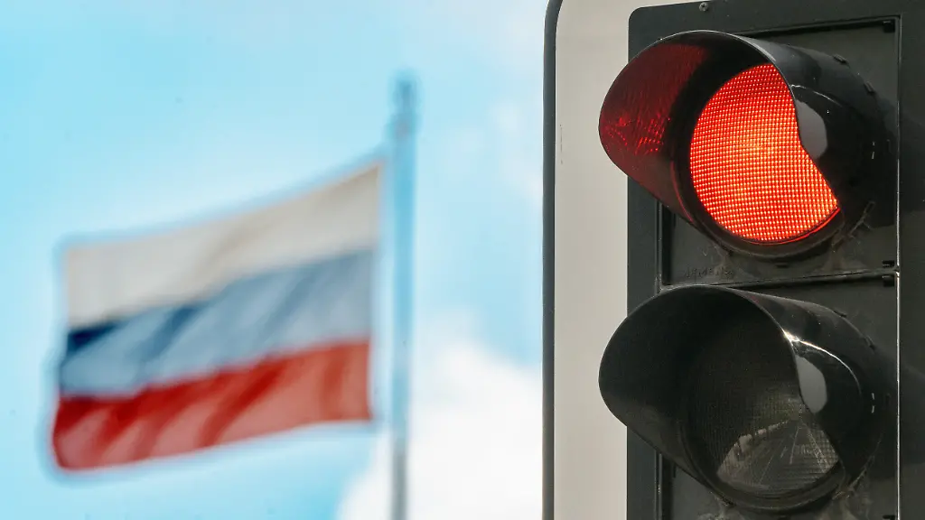 Deutschland-Berlin-Juli-2026-rote-Ampel-vor-russischer-Flagge-Symbolfoto-Sanktionen-gegen-Russland-Verkehrsampel-und-Fahne-auf-dem-Dach-der-russischen-Botschaft-auf-der-Strasse-Unter-den-Linden-die-Sanktionen-der-EU-bestehen-seit-Beginn-des-Ukrainekriegs-2022-Wirtschaft-Politik