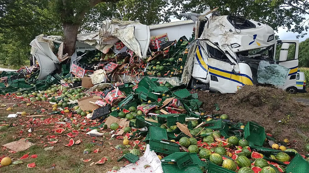 Melonen-liegen-neben-der-Fahrbahn-auf-einem-Acker-nachdem-ein-Lkw-gegen-einen-Baum-geprallt-ist-Das-Fuehrerhaus-wurde-dabei-massiv-zerstoert-der-Auflieger-seitlich-aufgerissen