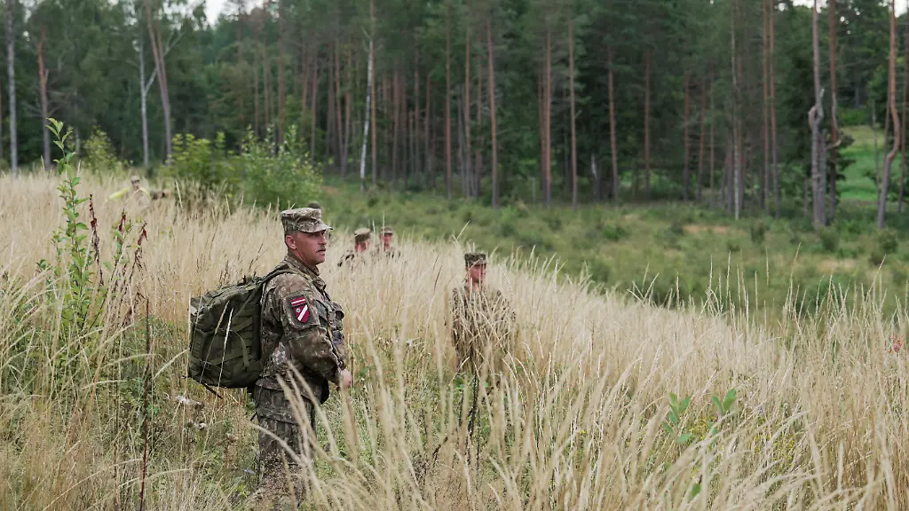 Servicemen-of-the-Latvian-National-Guard-walk-on-a-field-as-they-search-for-the-debris-from-an-intercepted-drone-amid-Russia-s-attack-on-Ukraine-in-Rugaji-Latvia-August-14-2026