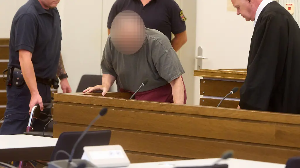 18-08-2026-Rheinland-Pfalz-Koblenz-Der-81-jaehrige-Angeklagte-2-v-l-kommt-mit-Rollator-zu-Beginn-des-Mordprozesses-am-Landgericht-in-den-Gerichtssaal-und-nimmt-neben-Anwalt-Volker-Klein-r-Platz-Er-soll-1994-die-Amerikanerin-Amy-Lopez-ermordet-haben-Ihm-wird-vorgeworfen-die-24-Jahre-alte-Frau-auf-dem-Felsenweg-unterhalb-der-Festung-Ehrenbreitstein-angesprochen-und-unter-falschen-Angaben-in-das-etwas-abseits-gelegene-General-von-Aster-Zimmer-gelotst-zu-haben