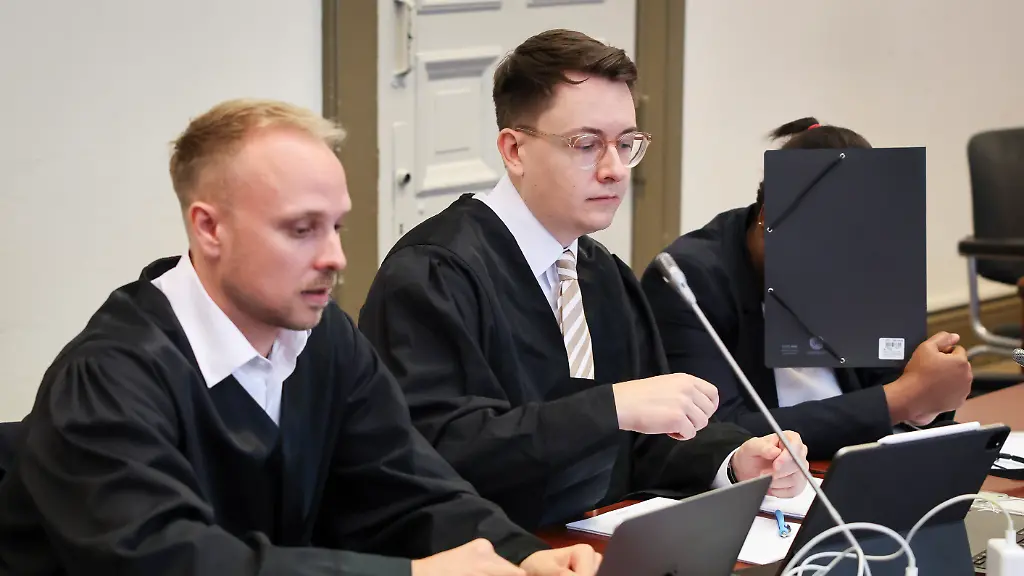 Die-Angeklagte-r-sitzt-neben-ihren-Anwaelten-Jonas-Meese-l-und-Alexander-Schlueter-zu-Beginn-eines-Mordprozesses-im-Gerichtssaal-im-Strafjustizgebaeude-und-verdeckt-ihr-Gesicht-Der-42-jaehrigen-Angeklagten-wird-Mord-in-Tateinheit-mit-Raub-mit-Todesfolge-vorgeworfen