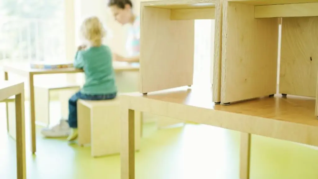 Eine-Erzieherin-und-ein-Kind-spielen-an-einem-Tisch