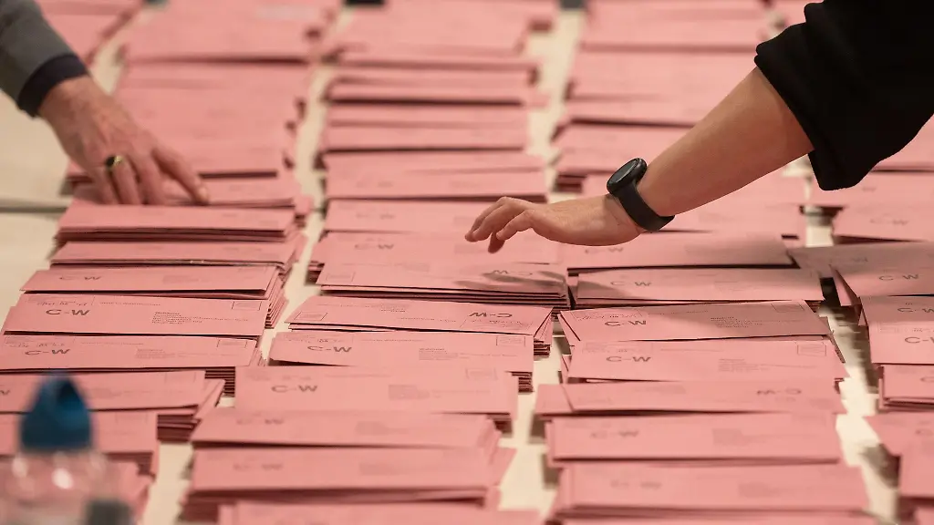 Briefwahlstimmen-liegen-zur-Auszaehlung-auf-einem-Tisch