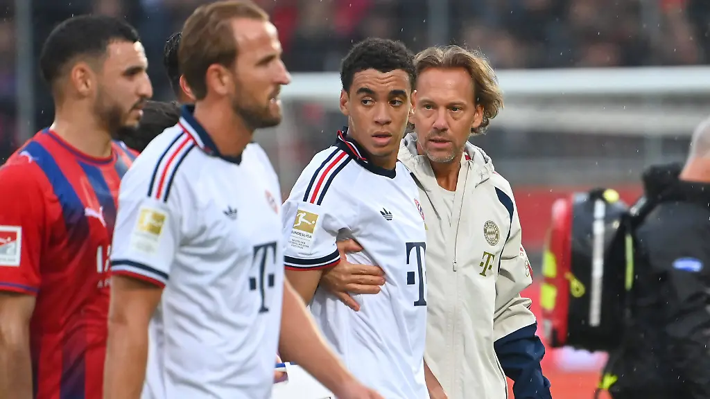 Jamal-MUSIALA-Bayern-Muenchen-bricht-erneut-zusammen-Ohnmacht-wird-von-Dr-Peter-UEBLACKER-Mannschaftsarzt-FCB-vom-Platz-gefuehrt-li-Harry-KANE-Bayern-Muenchen-Fussball-Testpiel-1-FC-Heidenheim-FC-Bayern-Muenchen-2-5-am-18-08-2025-VOITH-ARENA-Jamal-MUSIALA-of-Bayern-Munich-collapses-again-faints-is-led-off-the-field-by-Dr