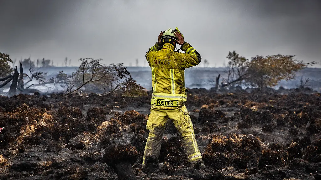 Ein-Feuerwehrmann-steht-am-Brandort-im-Naturschutzgebiet-Hohes-Venn-Die-Bekaempfung-des-Waldbrandes-ist-wegen-des-torfhaltigen-Bodens-in-dem-Naturschutzgebiet-besonders-schwierig