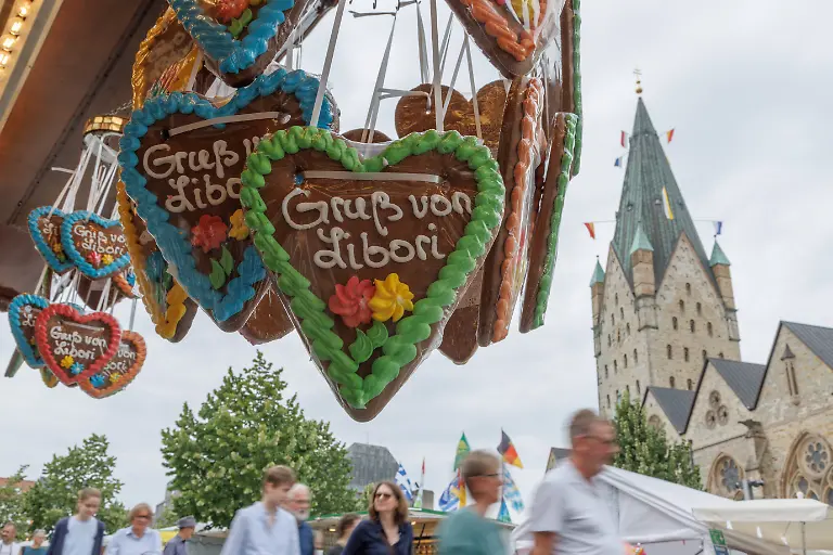 Gruss-von-Libori-steht-auf-einem-Lebkuchenherz-auf-dem-Libori-Im-Hintergrund-ist-der-Dom-von-Paderborn-zu-sehen-Die-Feier-zu-Ehren-des-heiligen-Liborius-ist-eines-der-groessten-und-aeltesten-Volksfeste-in-Deutschland-Paderborns-fuenfte-Jahreszeit