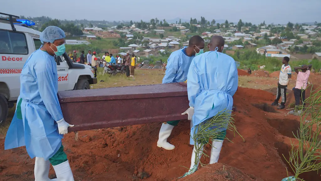 Menschen-in-Schutzkleidung-laden-einen-Sarg-mit-den-sterblichen-Ueberresten-eines-sechsjaehrigen-Kindes-das-an-Ebola-gestorben-ist-fuer-eine-Beerdigung-in-Bunia-in-der-Provinz-Ituri-im-Osten-der-Demokratischen-Republik-Kongo-ab