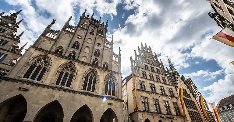 Das-Historische-Rathaus-von-Muenster-l-in-Westfalen-am-Prinzipalmarkt-ist-eines-der-Wahrzeichen-der-Stadt-Als-erste-Grossstadt-Nordrhein-Westfalens-hat-Muenster-nach-dem-Vorbild-anderer-Staedte-einen-sogenannten-Klimanotstand-ausgerufen-Nach-Angaben-der-Stadt-stellte-der-Stadtrat-am-Mittwoch-in-einem-entsprechenden-Beschluss-fest-dass-die-Eindaemmung-des-vom-Menschen-verursachten-Klimawandels-in-der-staedtischen-Politik-eine-hohe-Prioritaet-besitze-und-bei-allen-Entscheidungen-grundsaetzlich-zu-beachten-sei
