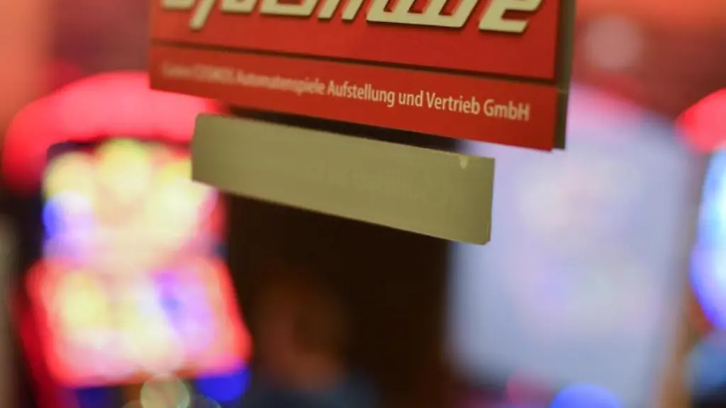 Ein-Aufkleber-mit-der-Aufschrift-Spielhalle-haengt-an-der-Glastuer-einer-Spielothek