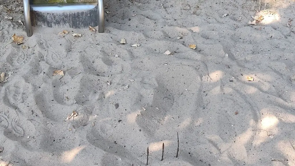 Mit-den-Zinken-nach-oben-lag-die-Mistgabel-vor-der-Rutsche-im-Sand