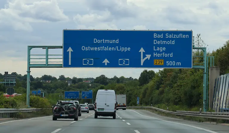 Nordrhein-Westfalen-Deutschland-Europa-Grosse-blaue-Wegweisertafel-ueber-einer-Bundesautobahn-mit-Richtungsangaben-nach-Dortmund-Ostwestfalen-Lippe-sowie-Bad-Salzuflen-Detmold-Lage-und-Herford-Mehrspurige-Autobahn-mit-Fahrzeugverkehr-unter-bewoelktem-Himmel-Symbolbild-fuer-Verkehr-Infrastruktur-Navigation-und-Fernstrassen-North-Rhine-Westphalia-Germany-Europe-A-large-blue-highway-sign-above-a-federal-highway-indicating-directions-to-Dortmund-East-Westphalia-Lippe-as-well-as-Bad-Salzuflen-Detmold-Lage-and-Herford-A-multi-lane-highway-with-traffic-under-a-cloudy-sky