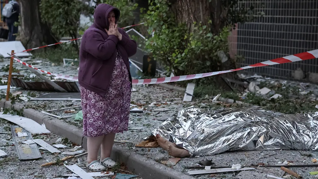 SENSITIVE-MATERIAL-THIS-IMAGE-MAY-OFFEND-OR-DISTURB-A-woman-reacts-near-the-body-of-a-resident-killed-at-a-site-of-an-apartment-building-destroyed-by-a-Russian-missile-strike-amid-Russia-s-attack-on-Ukraine-in-Kyiv-Ukraine-August-20-2026