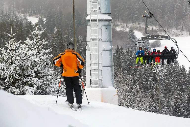 Touristen-sind-am-zweiten-Weihnachtstag-2021-waehrend-der-Coronapandemie-im-Skigebiet-von-Winterberg-Hochsauerlandkreis-NRW-unterwegs-Dank-Kunstschnee-sind-viele-Skilifte-und-Pisten-bei-Temperaturen-um-den-Gefrierpunkt-geoeffnet