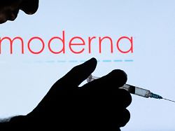 FILE PHOTO People Pose With Syringe With Needle In Front Of Displayed Moderna Logo In This Illustration Taken December 11 2021