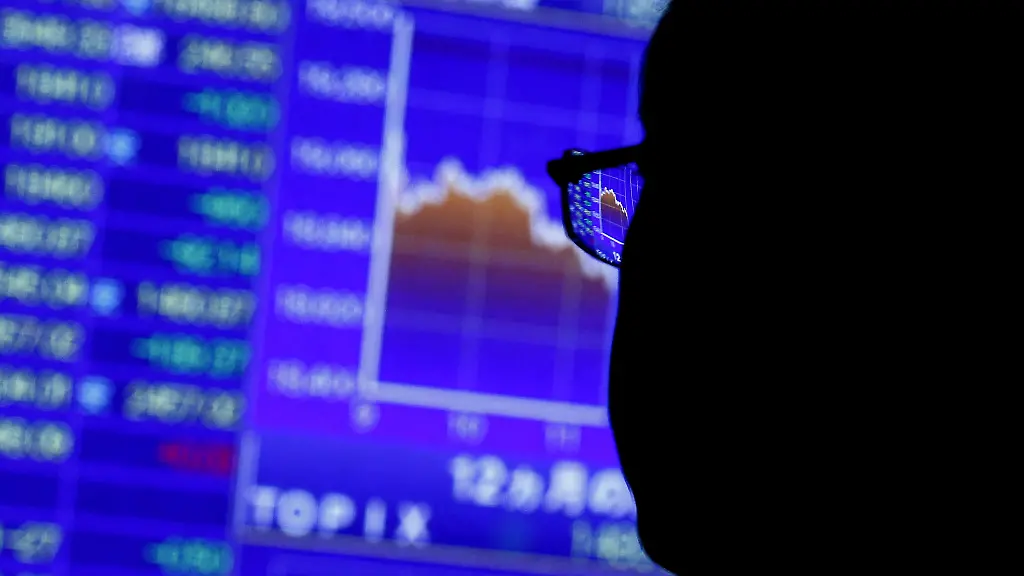 FILE-PHOTO-A-man-looks-at-market-indexes-at-a-stock-quotation-board-outside-a-brokerage-in-Tokyo-August-24-2015