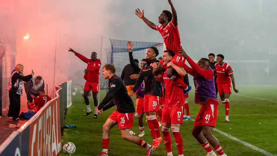 DFB-Pokal-SV-Waldhof-Mannheim-vs-1-FC-Kaiserslautern-21-08-2026-Spieler-des-1-FC-Kaiserslautern-feiern-nach-Abpfiff-den-1-0-Sieg-gegen-den-SV-Waldhof-Mannheim-gemeinsam-mit-den-mitgereisten-Fans-vor-dem-Gaesteblock-Im-Fanblock-wird-Pyrotechnik-gezuendet-Spieler-im-Fokus-Erencan-YardAemcAe-1-FC-Kaiserslautern-17-und-Torschuetze-Ibrahim-KanatA-1-FC-Kaiserslautern-11-DFB-Pokal-SV-Waldhof-Mannheim-vs-1-FC-Kaiserslautern-Carl-Benz-Stadion-21-08-2026-DFB-DFL-REGULATIONS-PROHIBIT-ANY-USE-OF-PHOTOGRAPHS-AS-IMAGE-SEQUENCES-AND-OR-QUASI-VIDEO-DFB-Cup-SV-Waldhof-Mannheim-vs-1-FC-Kaiserslautern-August-21-2026-Players-from-1-FC-Kaiserslautern-celebrate-their-10-victory-over-SV-Waldhof-Mannheim-after-the-final-whistle-together-with-the-traveling-fans-in-front-of-the-visitors-section-Pyrotechnics-are-set-off-in-the-fan-section-Player-spotlight-Erencan-Yardimsi-1-FC-Kaiserslautern-No-17-and-goal-scorer-Ibrahim-Kanat-1-FC-Kaiserslautern-No-11-DFB-Cup-SV-Waldhof-Mannheim-vs