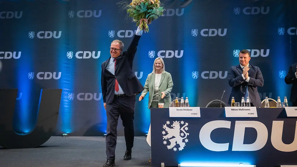 Mario-Voigt-CDU-l-Ministerpraesident-von-Thueringen-winkt-nach-seiner-Wiederwahl-zum-Landesvorsitzenden-der-CDU-Thueringen-mit-einem-Blumenstrauss-Die-CDU-Thueringen-kam-zu-ihrem-41-Landesparteitag-in-der-Werner-Assmann-Halle-zusammen