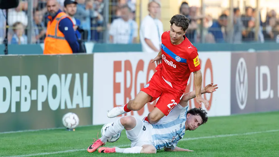 Moritz-Reimers-22-Holstein-Kiel-und-Lance-Fiedler-47-TSV-1860-Muenchen-beim-Spiel-zwischen-TSV-1860-Muenchen-v-Holstein-Kiel-Fussball-Herren-Dfb-Pokal-2026-2027-1-Runde-am-22-08-2026-in-Muenchen-Staedtisches-Stadion-an-der-Gruenwalder-Strasse