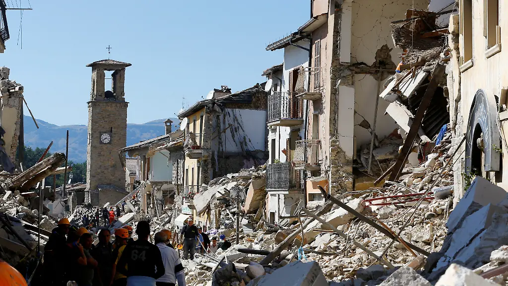 FILE-PHOTO-People-stand-next-collapsed-buildings-following-an-earthquake-in-Amatrice-central-Italy-August-24-2016