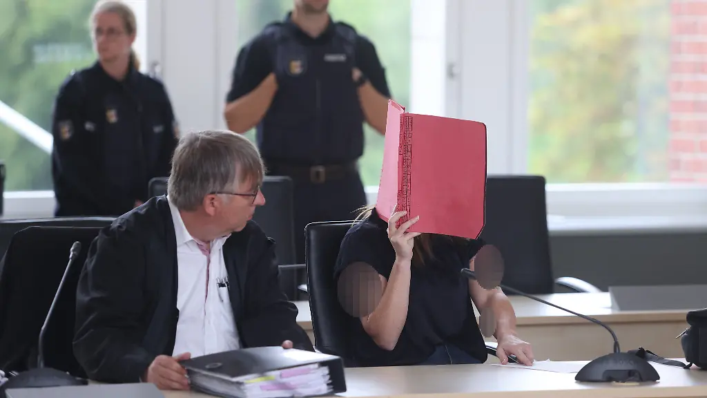 Die-Angeklagte-r-und-der-Anwalt-Andreas-Ohm-li-sitzen-im-Verhandlungssaal-des-Landgerichts-Rostock-vor-dem-Beginn-der-Fortsetzung-im-Verfahren-wegen-Mordes-im-Fall-Fabian-Der-Angeklagten-wird-vorgeworfen-am-10-10-2025-heimtueckisch-und-aus-sonst-niedrigen-Beweggruenden-den-zur-Tatzeit-achtjaehrigen-Fabian-aus-Guestrow-getoetet-zu-haben