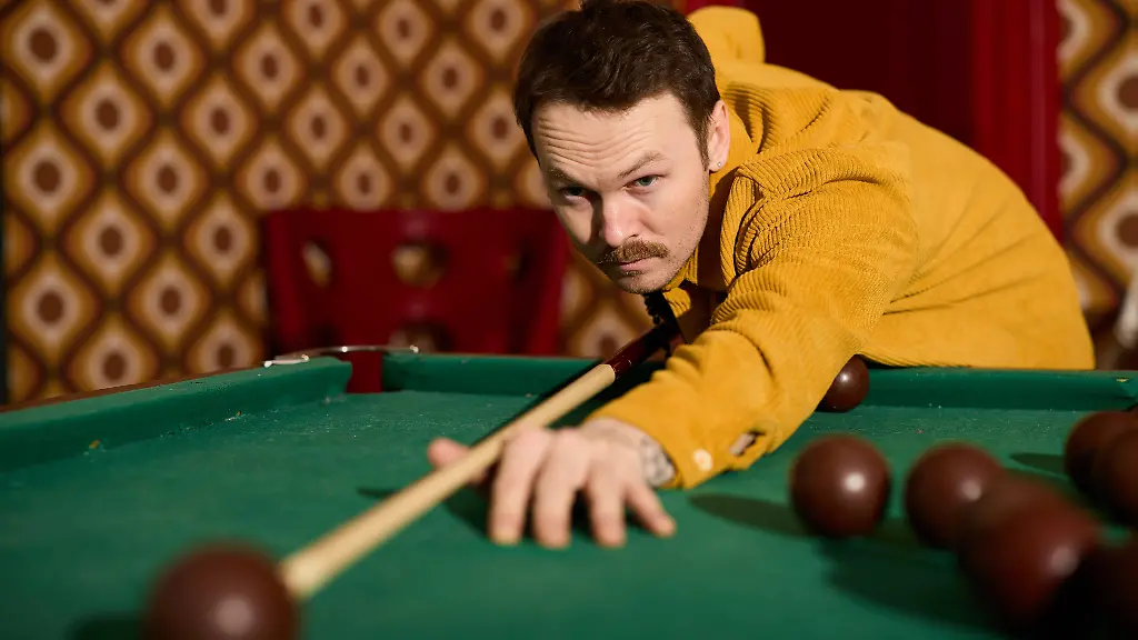 Mann in Cordhemd spielt Billard