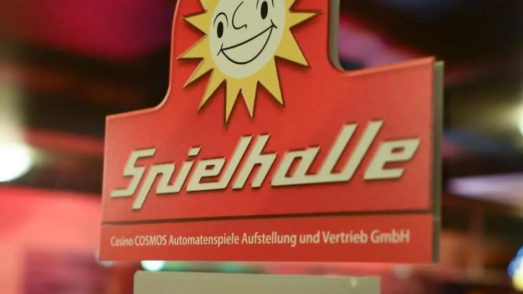 Ein-Aufkleber-mit-der-Aufschrift-Spielhalle-haengt-an-einer-Glastuer-einer-Spielothek