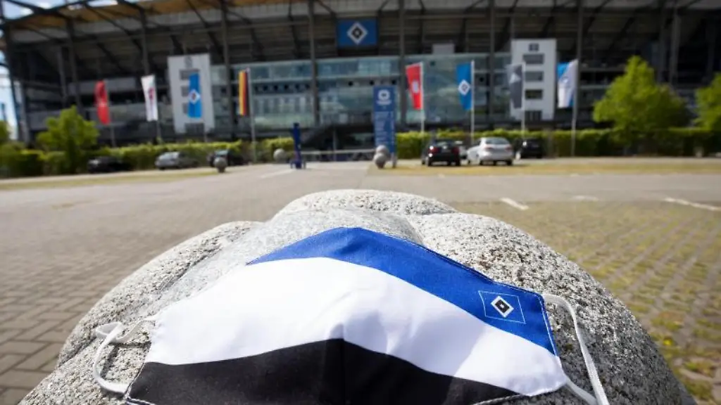 Ein-Mundschutz-in-den-Farben-des-HSV-liegt-vor-dem-Volkspark-Stadion