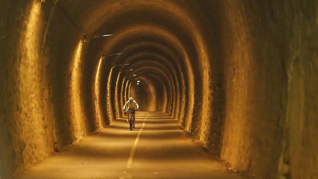 Ein-Radfahrer-faehrt-durch-einen-Tunnel-des-Maifeld-Radweges-der-auf-der-Trasse-einer-stillgelegten-Bahnstrecke-verlaeuft