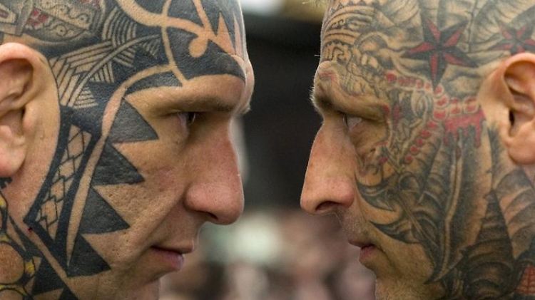 Der harte Kern: gesichtstätowierte Männer auf einer Tattoo-Convention.