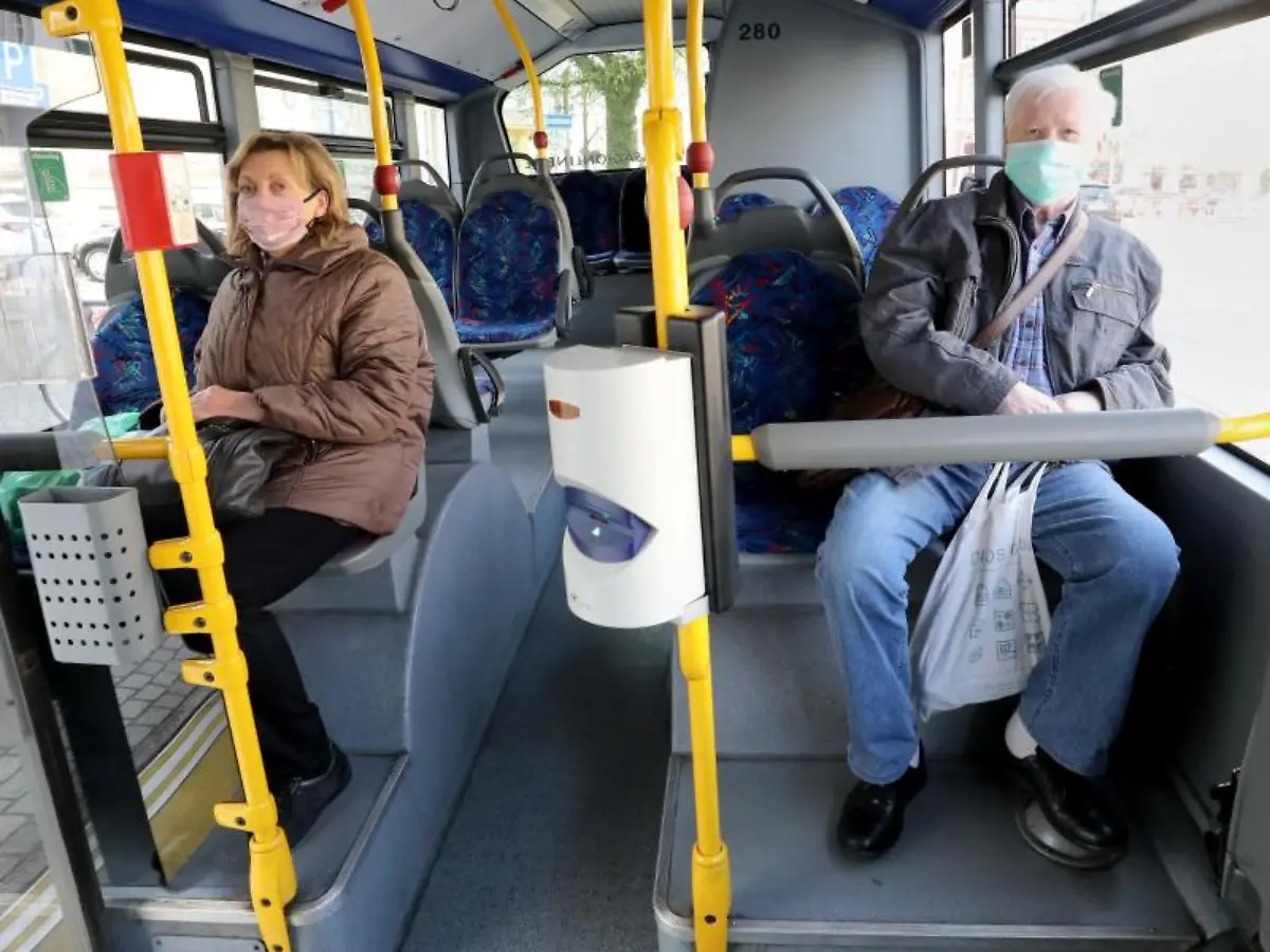 Fahrgaeste-sitzen-mit-Mund-Nasenbedeckung-in-einem-Bus