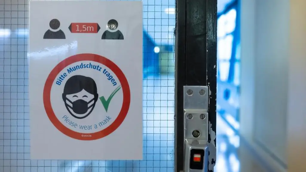 Ein-Schild-mit-der-Aufschrift-Bitte-Mundschutz-tragen-ist-in-einem-Flur-zu-sehen