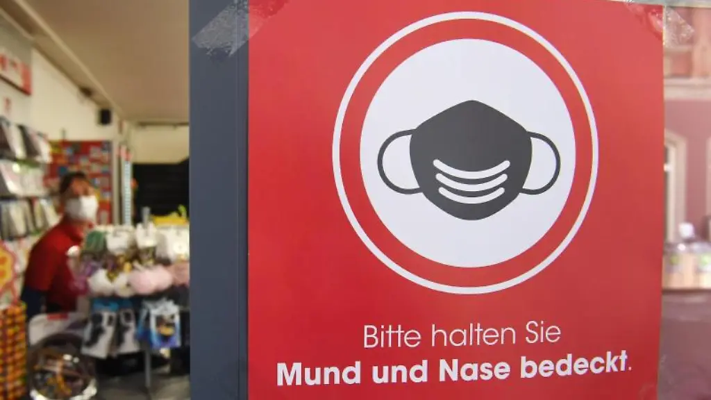 Ein-Schild-an-einem-Geschaeft-in-Stralsund-bittet-darum-Mund-und-Nase-bedeckt-zu-halten