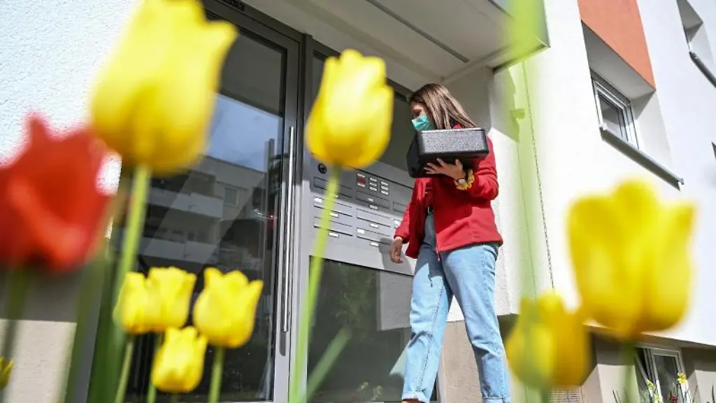 Stella-Dutschke-Mitarbeiterin-des-Deutschen-Roten-Kreuzes-traegt-Essen-in-einer-Thermobox