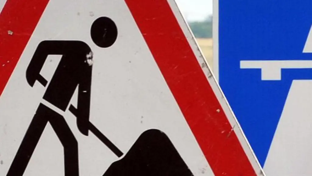Ein-Baustellenschild-ist-vor-einem-Autobahschild-platziert