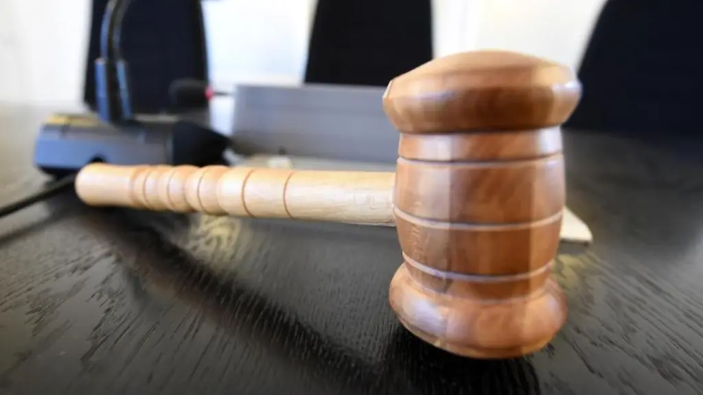 Auf-einer-Richterbank-im-Landgericht-liegt-ein-Richterhammer-aus-Holz
