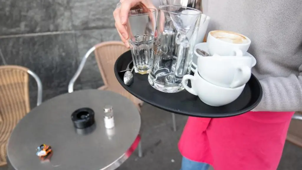 Ein-Kellner-raeumt-einen-Tisch-in-einem-Restaurant-ab