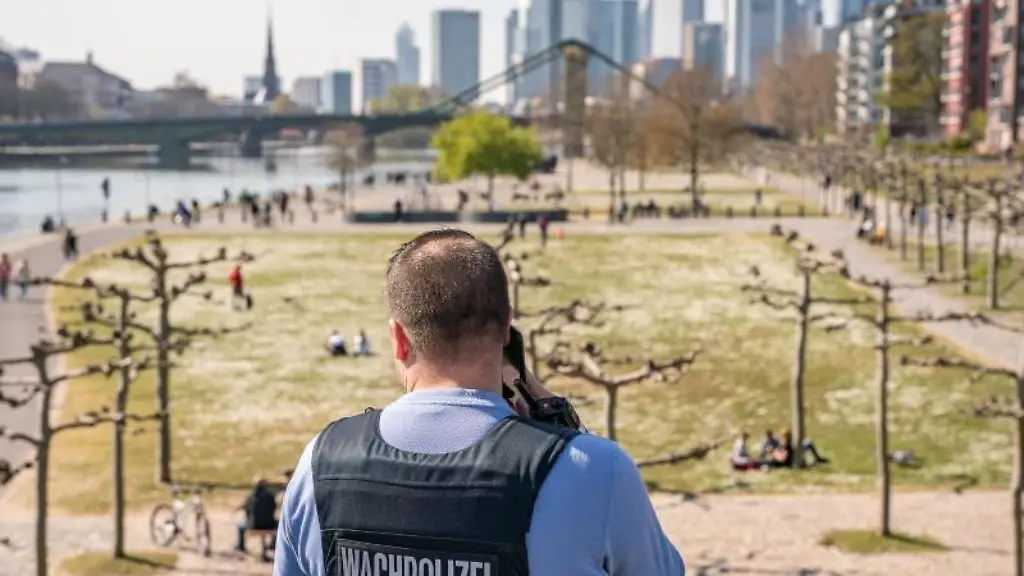 Ein-Mitglied-der-Wachpolizei-ueberprueft-am-Nachmittag-die-Einhaltung-der-Kontaktsperre-am-Mainufer