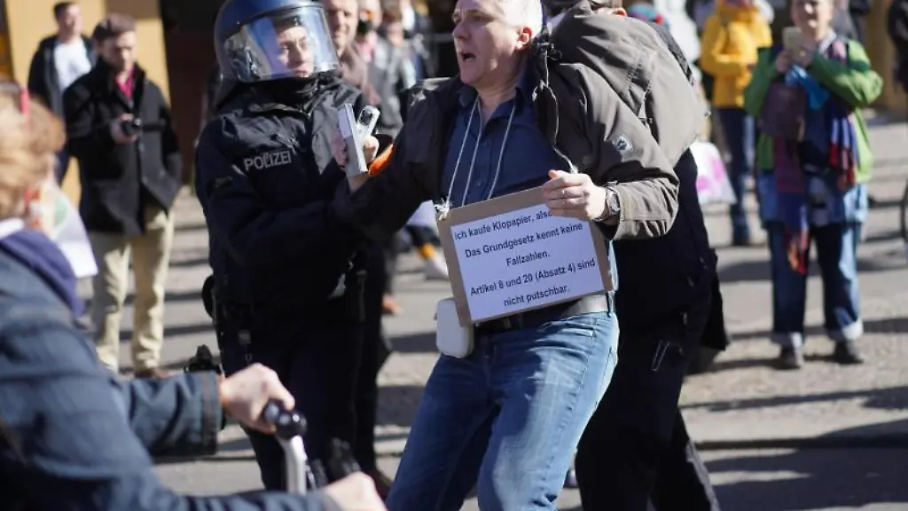 Ein-Demonstrationsteilnehmer-wird-von-Polizisten-abgefuehrt