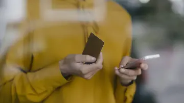 Frau mit gelben Shirt und Kreditkarte