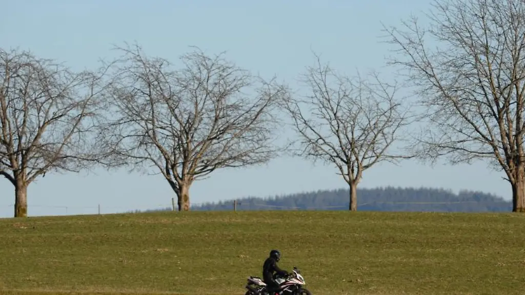 Ein-Motorradfahrer-faehrt-ueber-eine-Strasse