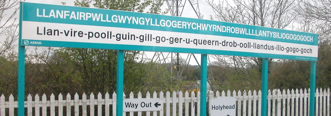 Der Bahnhof von Llanfairpwllgwyngyllgogerychwyrndrobwllllantysiliogogogoch auf Anglesey. Der Ort trägt den längsten und wohl auch kompliziertesten Namen Europas. Er bedeutet in etwa: "Kirche der Heiligen Maria in der Senke des weißen Haselbusches in der Nähe des schnellen Wasserstrudels und der Kirche des Heiligen Tysilio bei der roten Höhle".