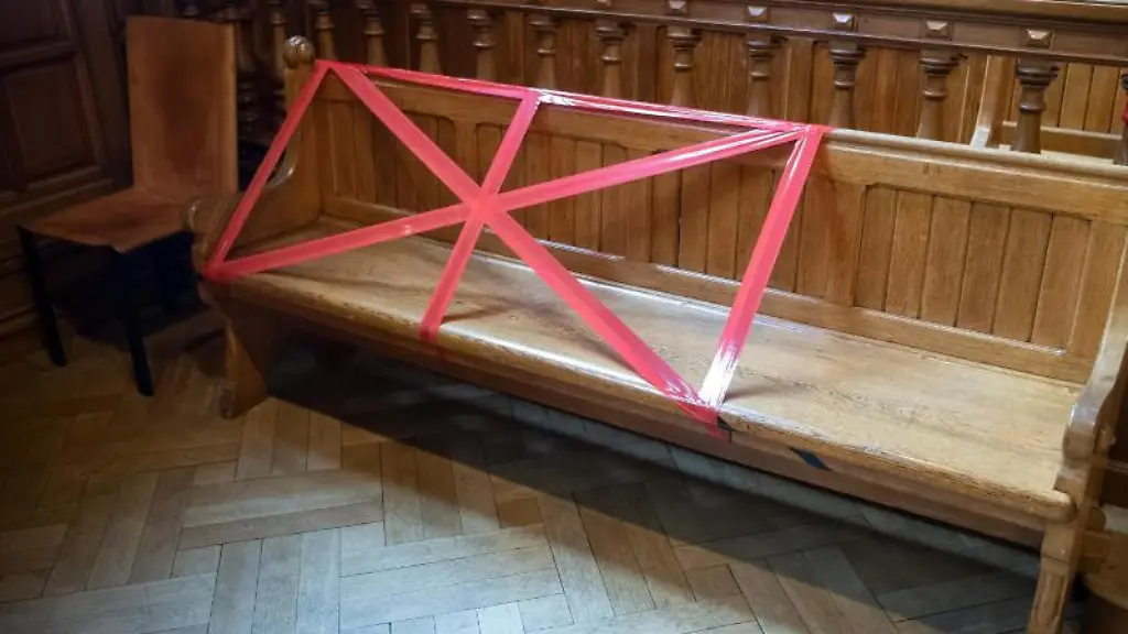 Die-Baenke-und-Tische-in-einem-Gerichtssaal-sind-mit-roten-Markierungen-abgeklebt-damit-waehrend-der-Corona-Krise-der-noetige-Sicherheitsabstand-eingehalten-wird