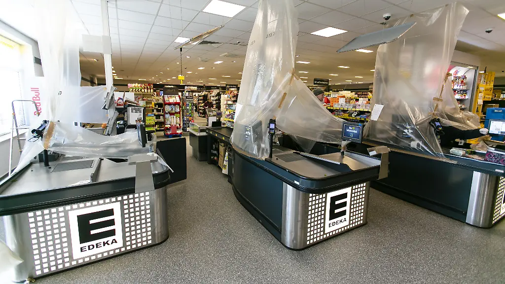 In-dieser-Edeka-Filiale-werden-die-Arbeitsplaetze-der-Kassiererinnen-und-Kassierer-fuer-ihren-Schutz-mit-Plastikfolie-abgehaengt