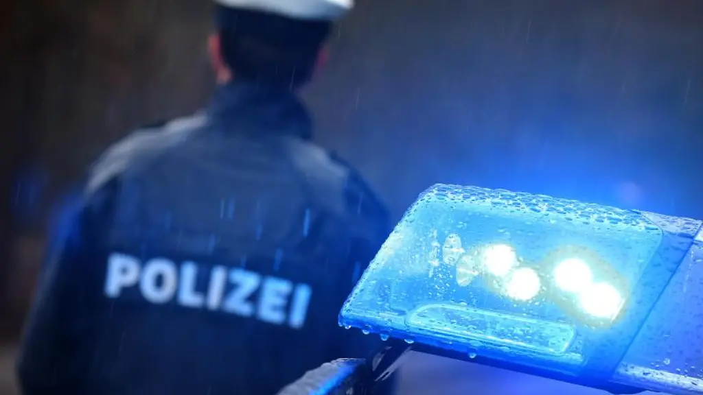 Ein-Polizist-steht-neben-einem-Streifenwagen