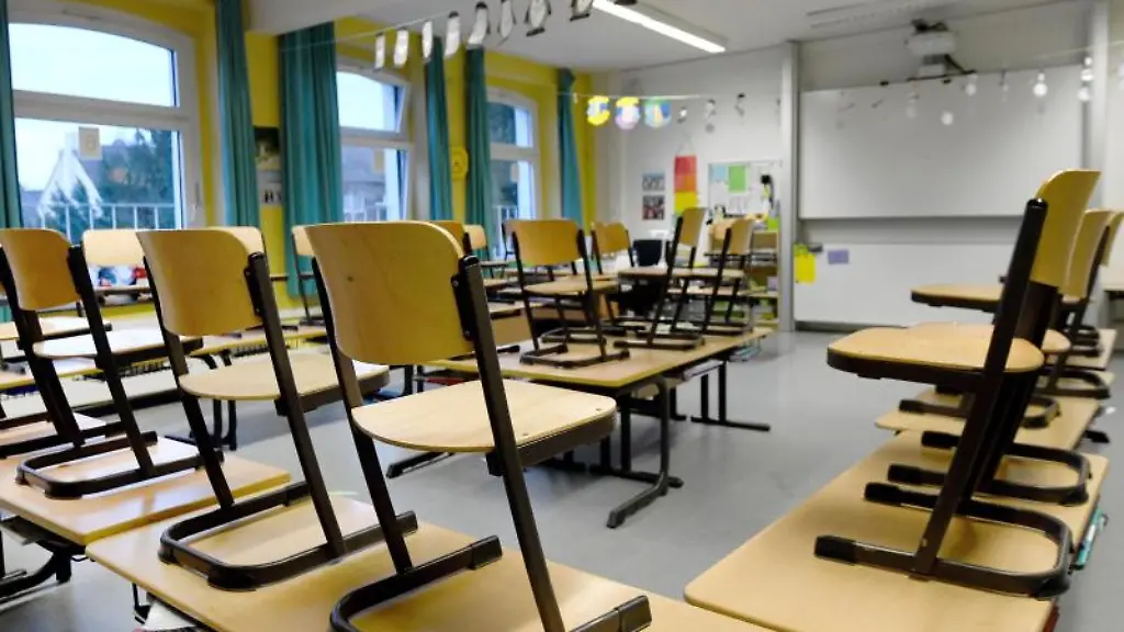 Stuehle-stehen-in-einem-Klassenzimmer-in-einer-Grundschule-auf-den-Tischen