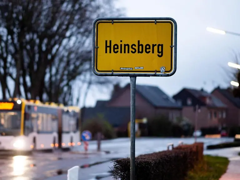 Ein-Bus-faehrt-am-Ortsschild-von-Heinsberg-vorbei