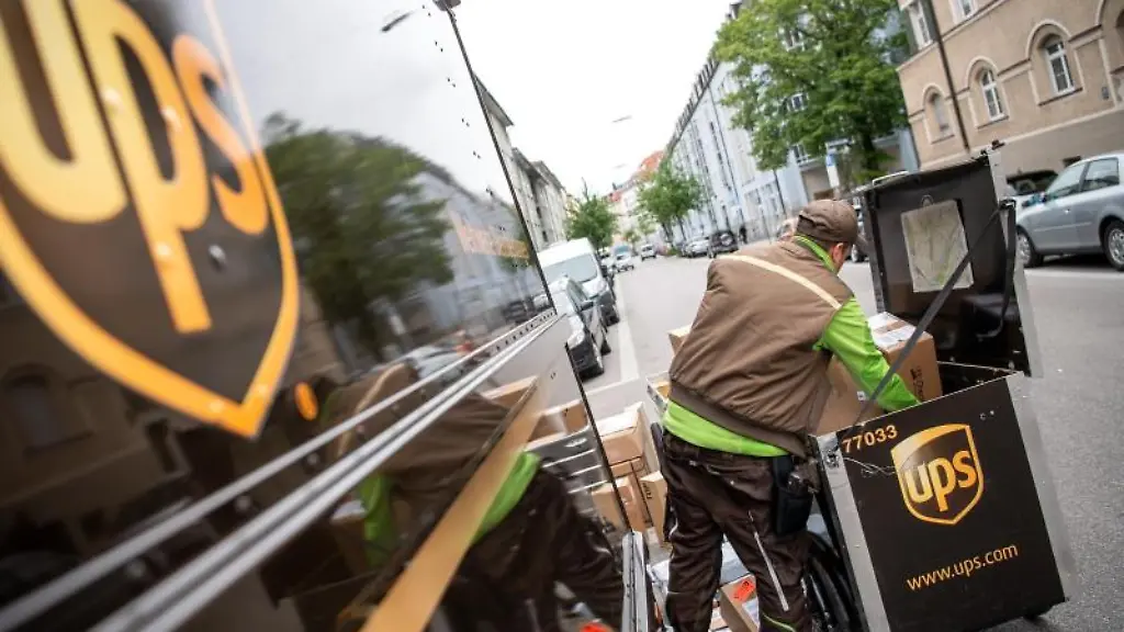 Ein-Paketbote-von-UPS-laedt-Pakete-in-einen-Transporter