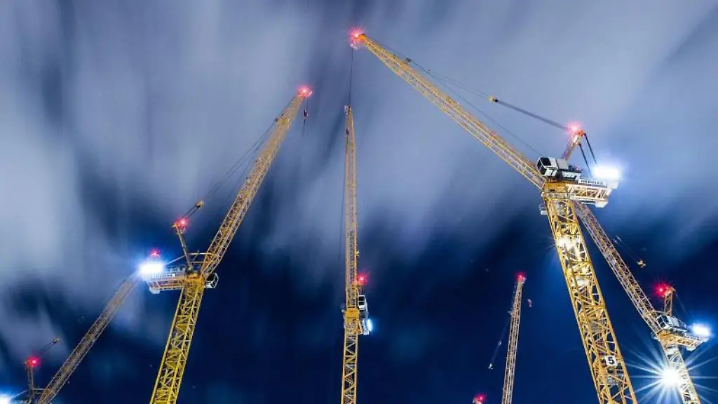 Wolken-ziehen-ueber-Baukraene-auf-einer-Grossbaustelle-hinweg